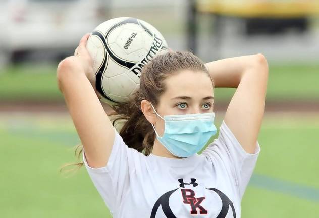 The new look of soccer: Shannon Dove passes the ball inbounds with her mask on.