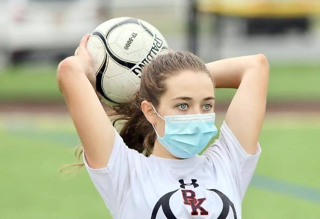 The new look of soccer: Shannon Dove passes the ball inbounds with her mask on.