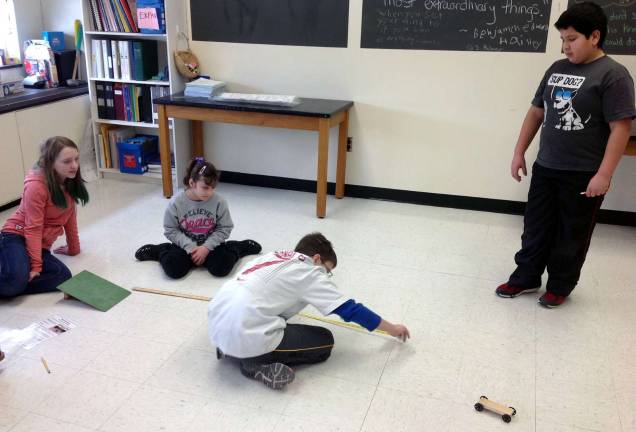 Photos provided In this &#xfe;&#xc4;&#xf2;STEaM&#xfe;&#xc4;&#xf4; lesson, North Main fifth-grade students test their cars and measure the distance they traveled under different conditions, then record the data.