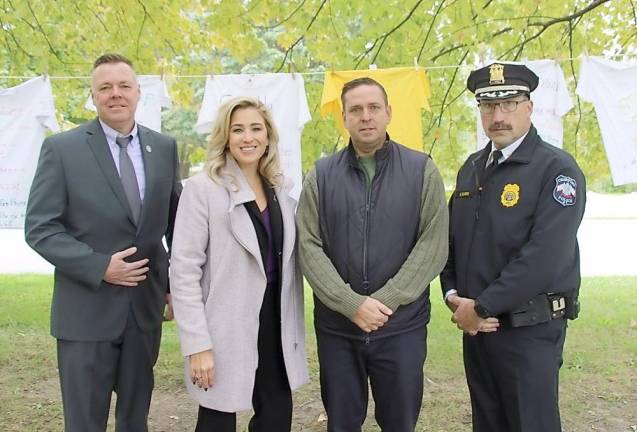 (From left to right) Port Jervis Police Chief William Worden, Kellyann Kostyal-Larrier, Executive Director of Fearless!, Orange County Executive Steven M. Neuhaus and Town of Crawford Police Chief Dominick Blasko in front of the Clothesline Project;