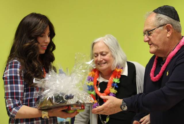 Rabbi Pesach and Chana Burston present a gift to Mitchell and Gladys Wenzel of Monroe for the Gregg Wenzel Scholarship Fund they established (Photo provided)