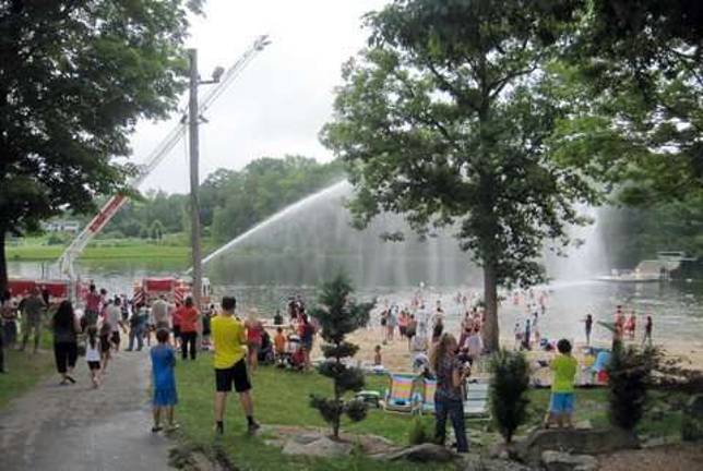Photos by Fred Ungerer Firefighters kept the crowd cool by dousing them from the aerial ladder.