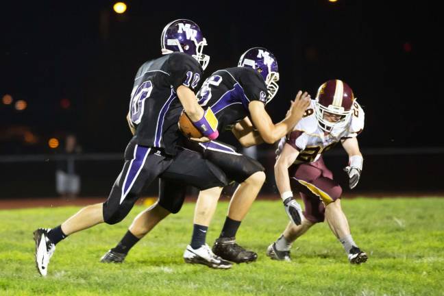 Photo by Don Beeler Monroe-Woodbury quarterback Kevin Carr follows guard Nick Marino as he prepares to block a Kingston defender.