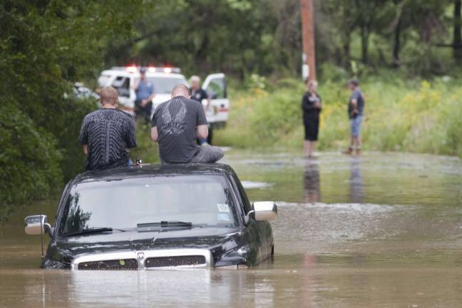 Photo by Robert G. Breese Two men sit stranded on their pickup on Blooms Corners Road last summer as the Wawayanda Creek surrounds them, and responders from Warwick and Pine Island try to figure out the best way to reach them.