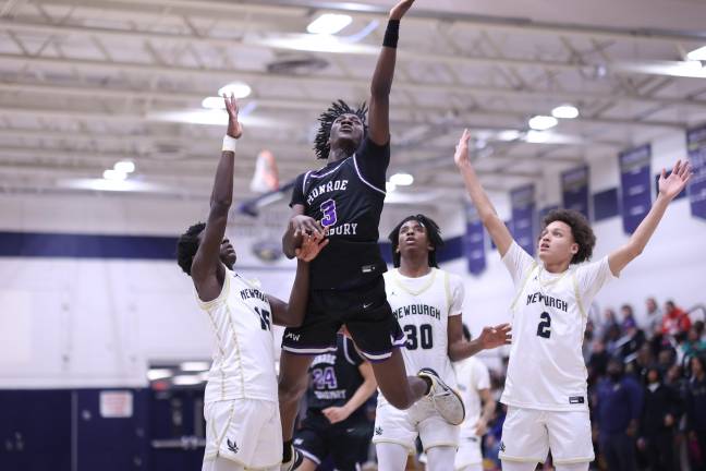 Fabrice Ndja, #3, crashes through three Goldback defenders to score two of 19 points in the game.