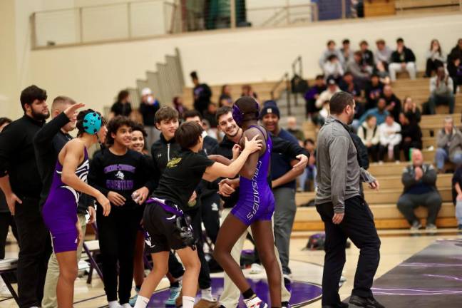 Devin Charles is greeted by coaches and teammates after his last and second victory.