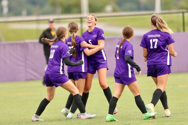 Kylie Baisley #5 celebrates with team after a Crusader goal.