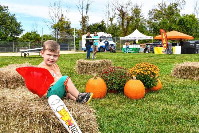 Cameron Riccardi of Stanhope plays among the pumpkins at the Stanhope Fall Festival on Saturday, Sept. 27. (Photo by Maria Kovic)