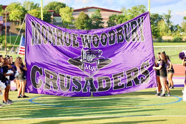 Crusader Cheerleaders hold the break away banner before the team takes the field.