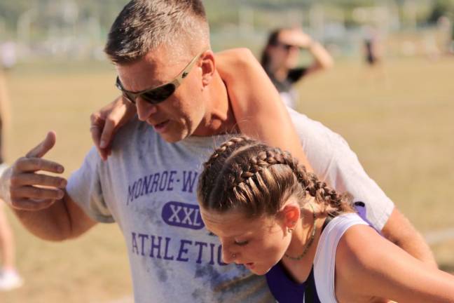 Crusader Mia Sisilli was helped to stay on her feet by Head Coach Chris Goodwin after finishing the race.
