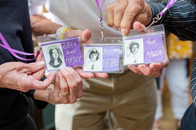 1973 MWHS graduates show off their yearbook photos on their name badges.