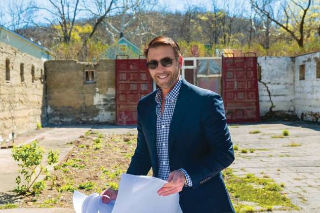Visionary behind the Tuxedo Hudson Company, Michael Bruno, stands in front of the remains of a massive, burned-out barn, which will become a European-style outdoor cafe attached to the French Resistance Coffee House.