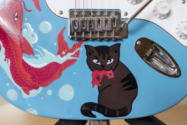 Taylor Lipnicky said one of her favorite tattoo styles is traditional Japanese because it often includes koi fish and cats, which she incorporated into the design of the guitar she created for the Virtual Chair Auction.
