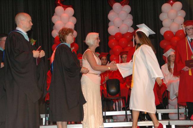 Principal Jason Schrammel, Superintendent Nancy Teed and School Board PresidentDiane Petrosky greet senior Karla Rachel Lopez Granillo, who closed the program with a well-received farewell address.