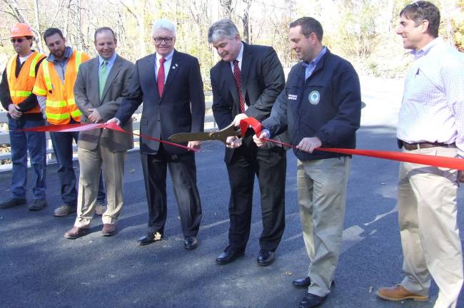 Photo provided by Orange County Orange County Legislator Kevin Hines cuts the ceremonial ribbon to celebrate the re-opening of the Taylor Road Bridge in Cornwall with the help of Orange County Executive Steven M. Neuhaus on Monday, Oct. 31. To the right of County Executive is John Balison of Hudson Valley Engineering Associates. They were joined by (from left to right) Jason Watzka and A.J. Feldt, also of Hudson Valley Engineering Associates, Department of Public Works Commissioner Chris Viebrock and County Legislator Barry Cheney.
