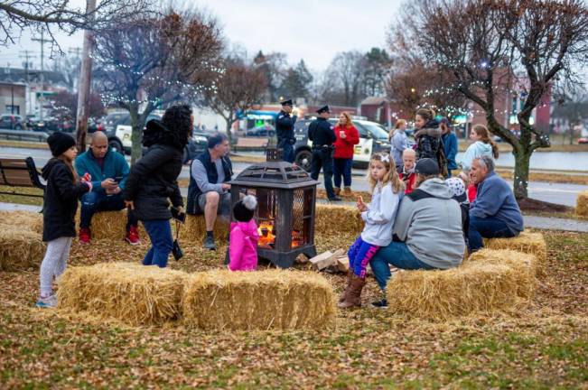Locals gathered around the fire drink hot coco and spend time with family at Monroe's Winter Festival.