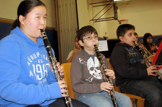 Photo by Nancy Kriz Music mentor Cara Steinberg plays the clarinet with North Main clarinets Leonard Velazquez, center, and Milton Santiago during band rehearsal.