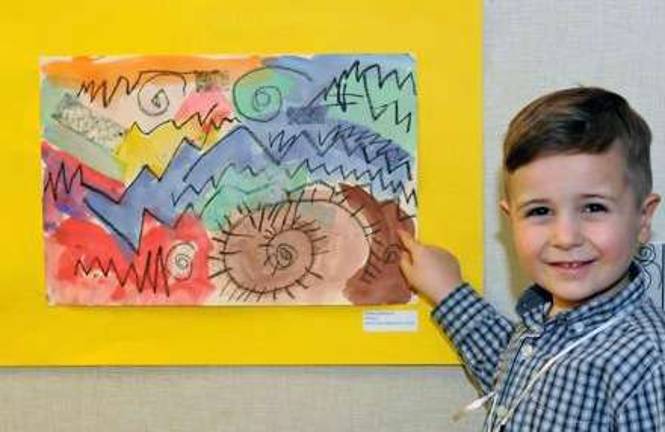 Smith Clove kindergartener Shane Lauterbach happily shows off his artwork, selected for participation in the Rushmore Library&iacute;s annual exhibit of student art from Smith Clove Elementary.