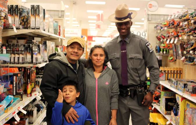 Ezequiel Florez with his mom and dad shopping with New York State Trooper Evantz Charmant.