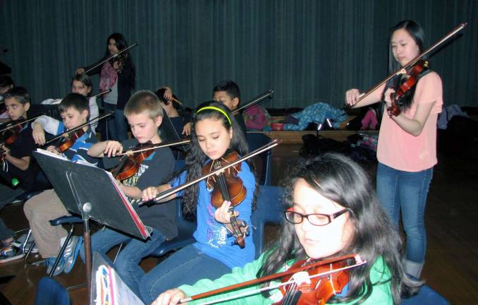 Photo by Nancy Kriz Standing behind the violin section are music mentors Jocelyn Ao, foreground, and Henal Shah, with North Main violinists Ernie Henriquez, front left, Dominick Vernola, Jack Aldred, Jayla Farinacci and Karyme Benitez.