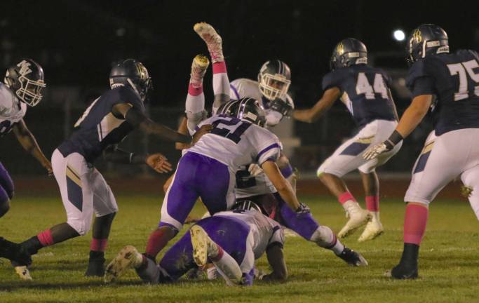 Crusaders Peter Mastropolo (#21) and Matt Seguniot (on the ground) send Pine Bush runner head over heels.