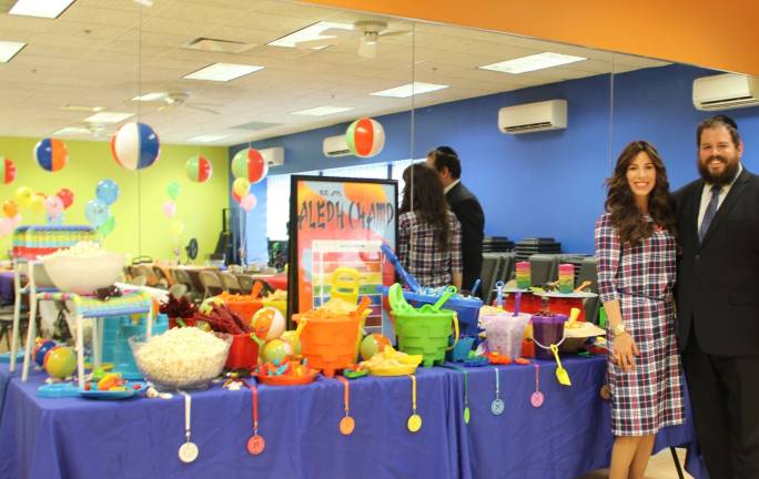 Rabbi Pesach and Chana Burston, directors of Chabad, in front of the special &#x201c;Aleph Champ&#x201d; snack bar display (Photo provided)