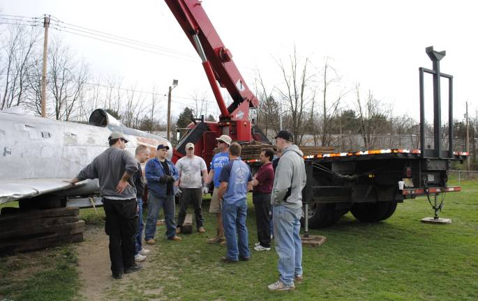 Volunteers work on the restoration of the Sabre Jet.