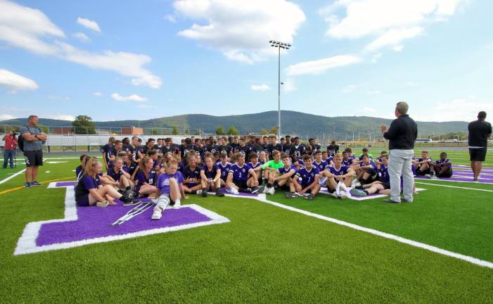 Athletic Director Lori Hock addresses the athletics at mid-field.
