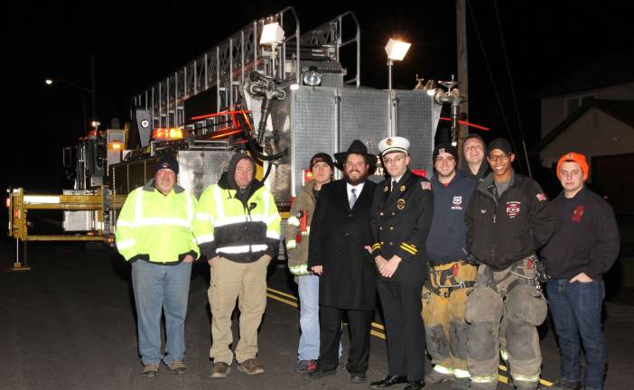The Monroe Village Fire Department, pictured here with Rabbi Pesach, will be providing a Firetruck Hanukkah Candy Drop, at Chabad&#x2019;s Menorah Lighting Ceremony Monday, Dec. 7 in Monroe.