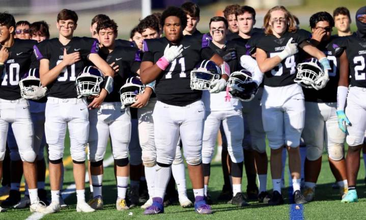 The Crusaders stand at attention for the National Anthem before their playoff game on Saturday against Middletown High School Middies. Photos by William Dimmit.