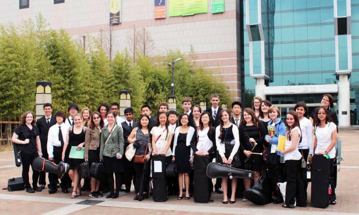 Members of the Orange County Youth Symphony pose for the camera outside one of the concert halls they performed in during their trip to South Korea.