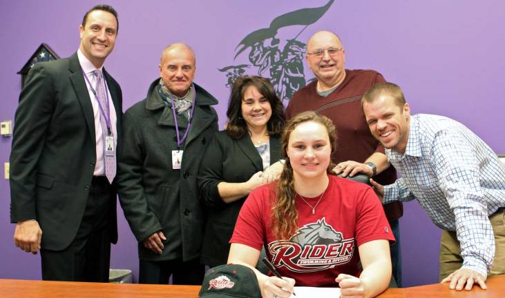 Photo provided by Carole Spendley/Monroe-Woodbury School District M-W High School Principal David Bernsley, Athletic Director Ron Montalto, parents Carmen and Peter Stalnaker and M-W Swimming Coach Justin Wright look on while Taylor Stalnaker signs a Letter of Intent to swim and attend school at Rider Univeristy in New Jersey.