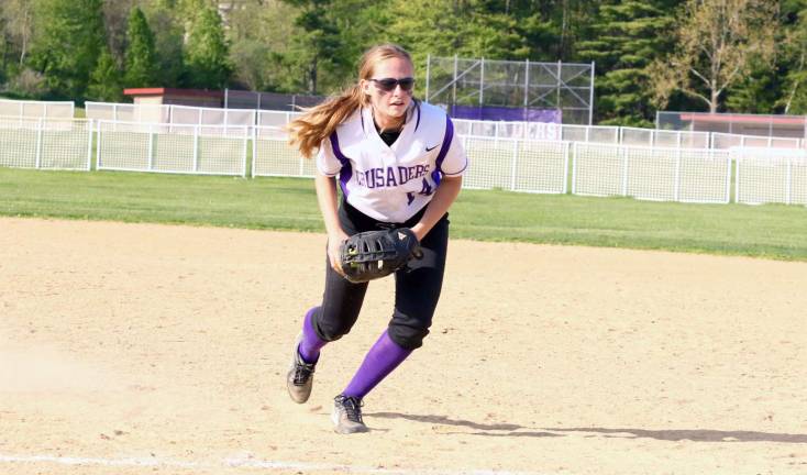 Madeline Leonard gathers up a ground ball and steps on first base.