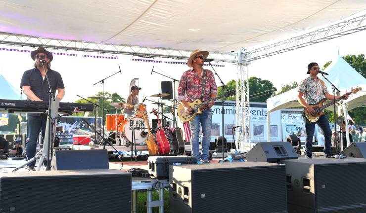 Robby Valentine and members of the Black Dirt Bandits play lively music for the thousands of people in attendance at the FreedomFest.