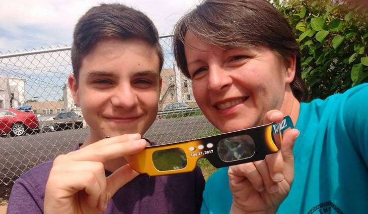 Photo via Facebook Monroe residents Jason Bieger and his mother Maggie Bieger show the glasses they used to watch the solar eclipse at the Monroe Free Library.