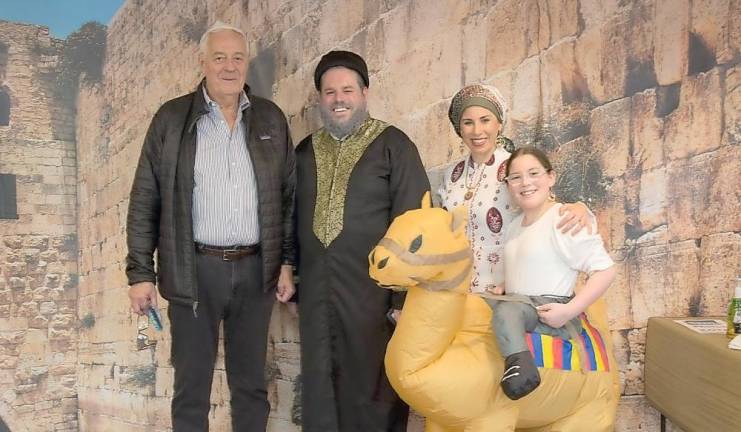 Al Muhlrad of Goshen takes a photo at the “Western Wall” in Jerusalem with Rabbi Pesach, Chana and Rivkah Burston at Chabad’s ‘Purim in Israel’ celebration.