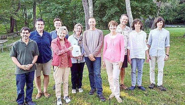 In the member photo from left to right are Paul Gluck, Gary Heavner, Nick Hill, Sally Sonne, Lili Neuhauser, Tom Fuller, Odeta Beggel, Bill, Bromley and Parker Givens.