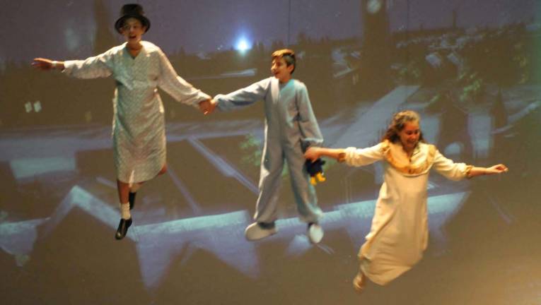 Photo by Bob Curtis The Darling children, from left to right: John (DJ Falone), Michael (Nicholas DeVita) and Wendy (Katharine Edel), soar above the rooftops of London as they fly with Peter Pan to Neverland during a recent dress rehearsal for Souza&#x2019;s Peter Pan, opening this weekend.