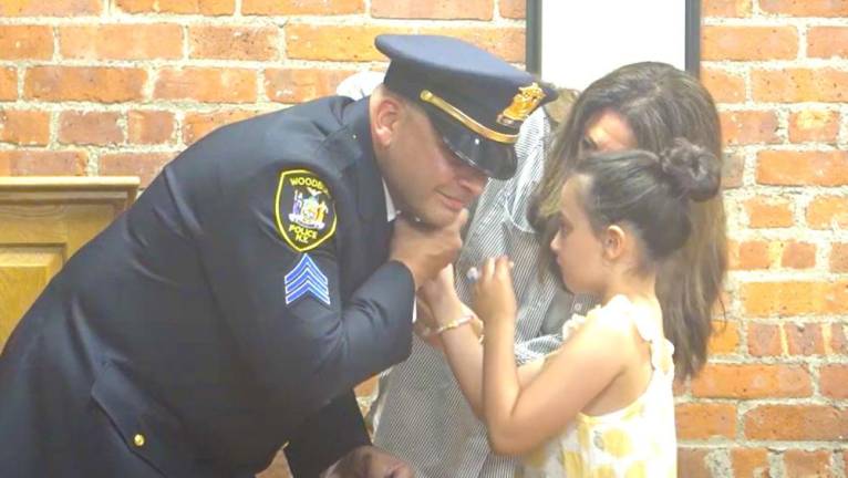 Woodbury Town Clerk Desiree Potvin administers the oath of office to Michael Faravashi of the Woodbury Police Department, who was promoted to the position of sergeant. The honor of pinning Faravashi was bestowed upon his wife and daughter.