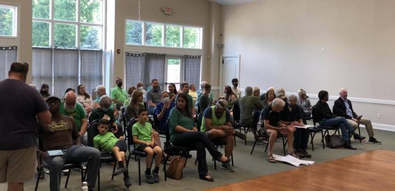 Members of Preserve Monroe, a newly formed environmental group, attended the July 14 planning board meeting dressed in green clothes to show their opposition to the Rye Hill Preserve.