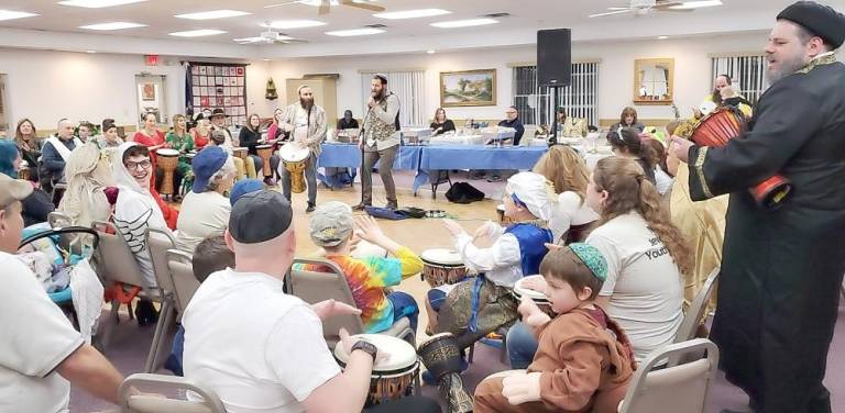 Percussionist Marlon Sobol leads an interactive drum-circle at Chabad’s ‘Purim in Israel’ celebration.