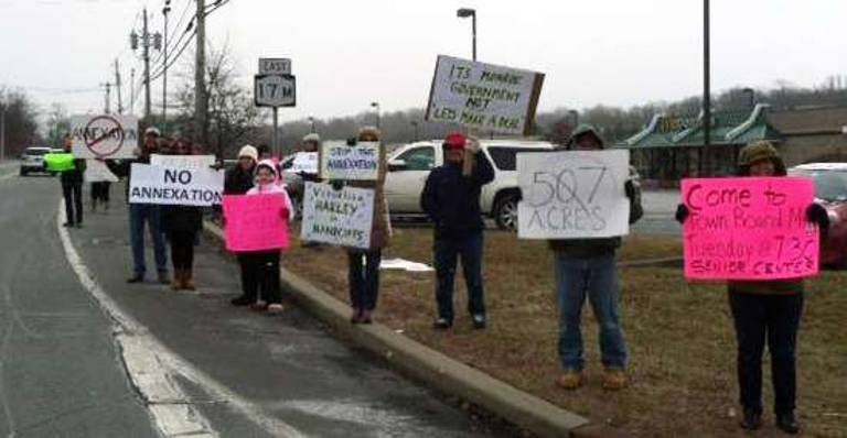 Taking to the street: People opposed to the annexation of property in the Town of Monroe to the Village of Kiryas Joel lined Route 17M in protest last Sunday.