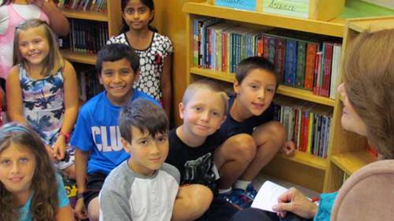 Lynn Caporale begins reading a book to her fourth-grade class, which includes Ava Rattazzi, Anu Gorukanti, Gio Ortiz, Kevin Mints, Jack Macri, Marley Vaught and Sam Kainatsky.