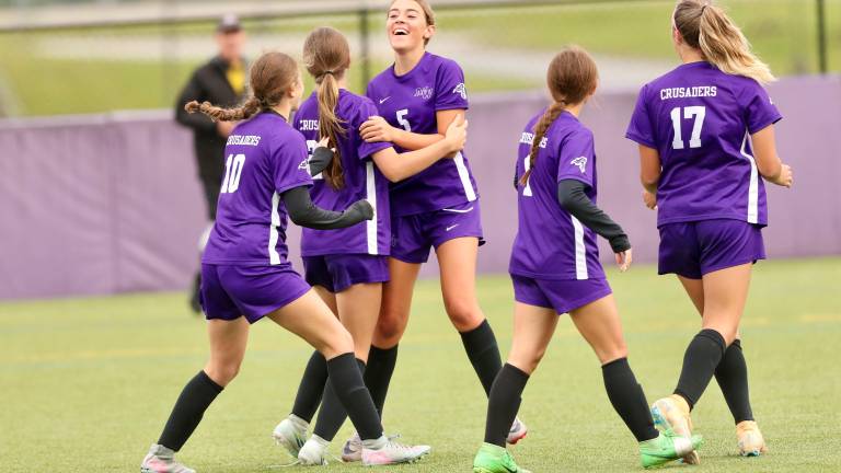 Kylie Baisley #5 celebrates with team after a Crusader goal.