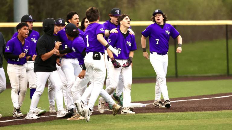 The Crusaders mob Joey Bauer #26 after he won the game with a single in the seventh.