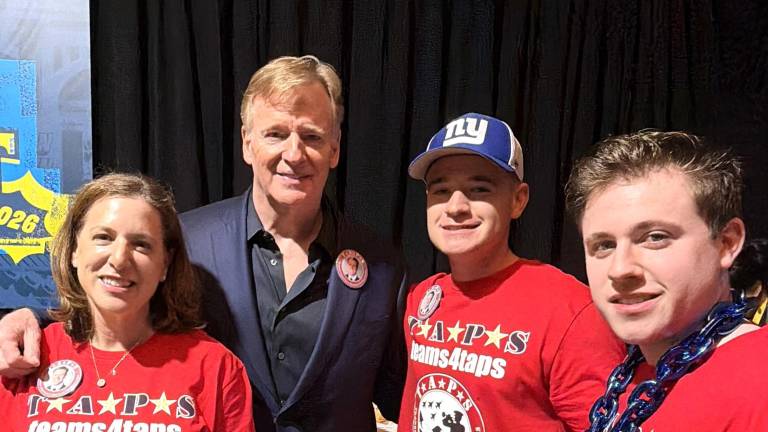 Traci Voelke with NFL Commissioner Roger Goodell and her sons Andrew Voelka and Ben Voelke.